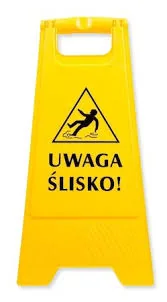 Żółty stojący znak ostrzegawczy: uwaga, ślisko.